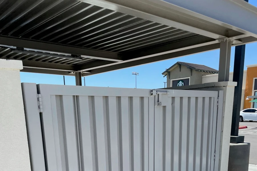 Custom fabricated steel gate and miscellaneous metal enclosure installed beneath a structural steel canopy
